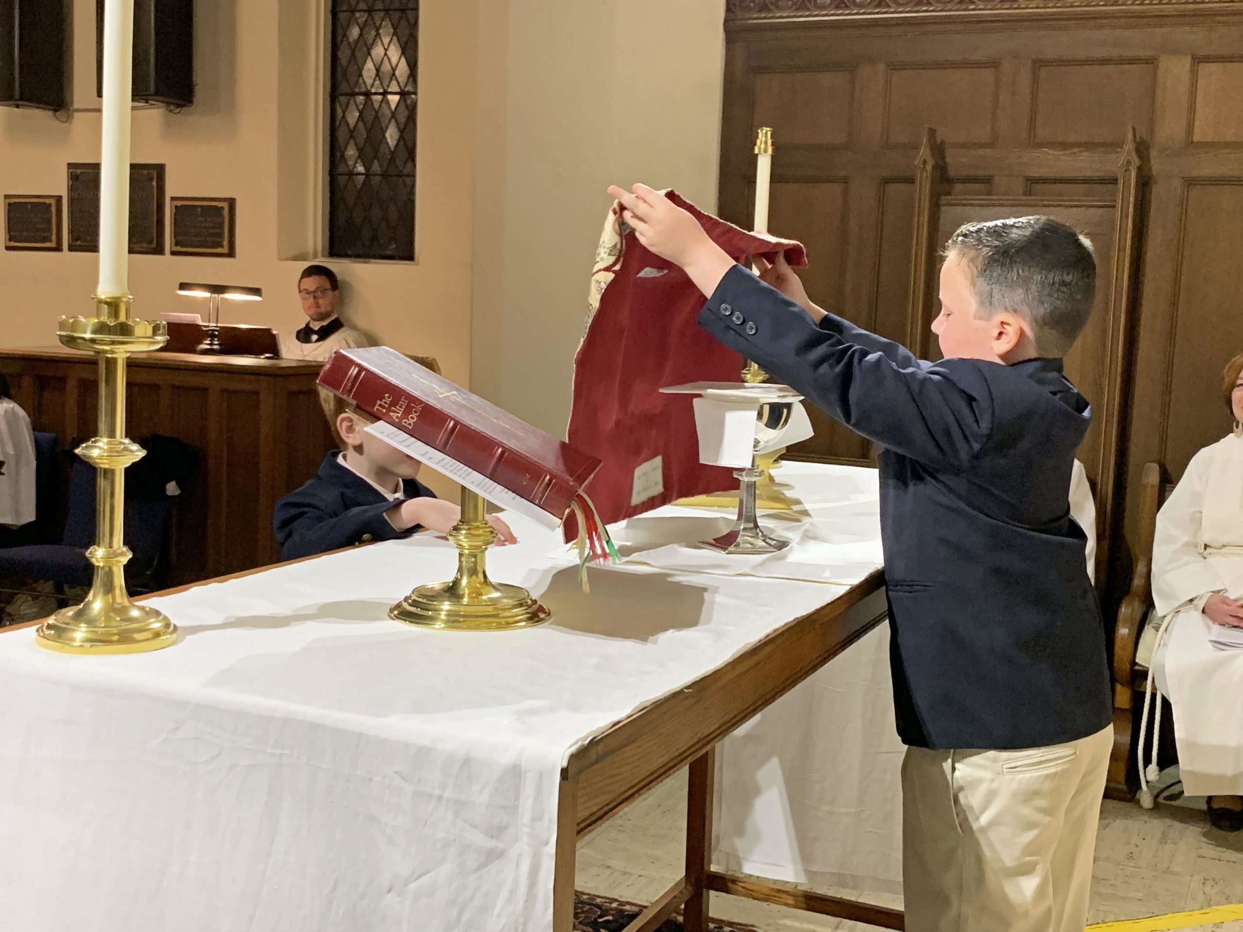 young boy preparing the alter for communion