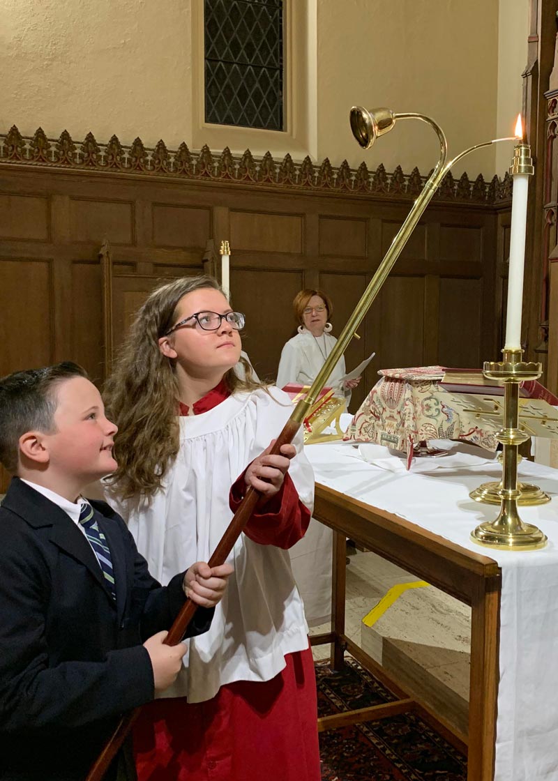 two children lighting a candle at a communion ceremony